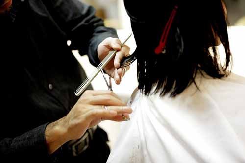 A client gets a haircut at a Georgia Cosmetology School